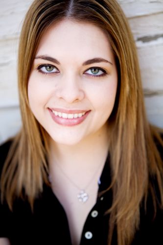 A young woman with long, straight light-brown hair smiling directly at the camera.
